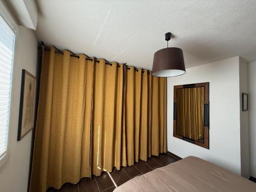 - une chambre avec des rideaux jaune moutarde et une fenêtre dans l'établissement Urban Retreat, classé 3 étoiles, à Ebersheim