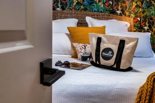 a bed with bags and a book on it at The Studio Southampton in Southampton