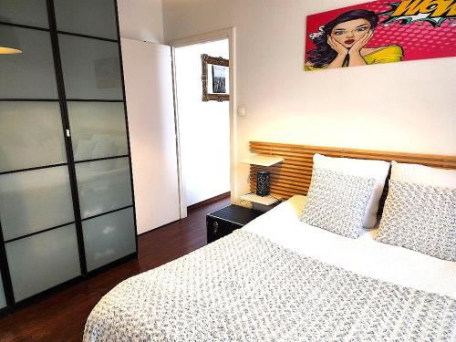 a bedroom with a bed and a painting on the wall at Appartement 3 pièces, Krutenau, Parking privé in Strasbourg