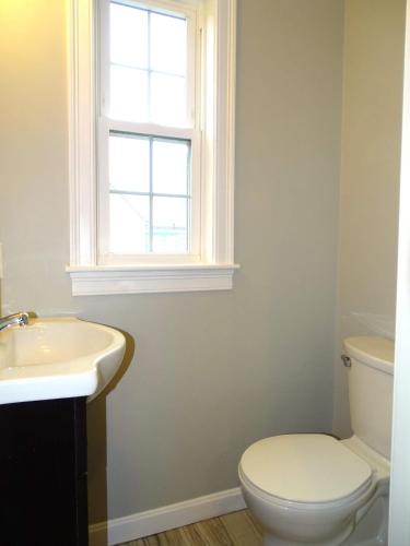 a bathroom with a toilet and a sink and a window at Beautiful 2 Bed Apt Minutes from Encore in Everett