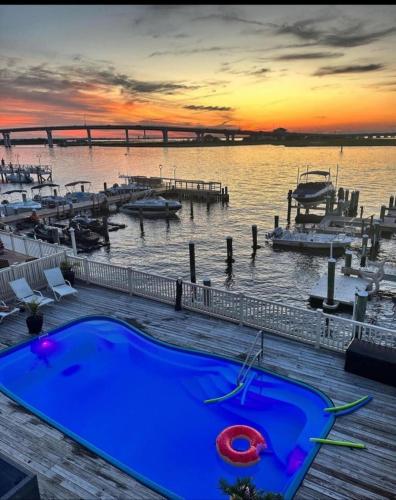 a blue swimming pool next to a dock with boats at Miami Vice Ocean City- 5BR | Private Pool | Views in Ocean City