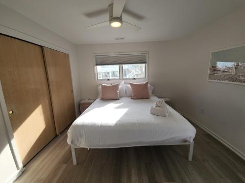 a bedroom with a large white bed with pink pillows at Miami Vice Ocean City- 5BR | Private Pool | Views in Ocean City