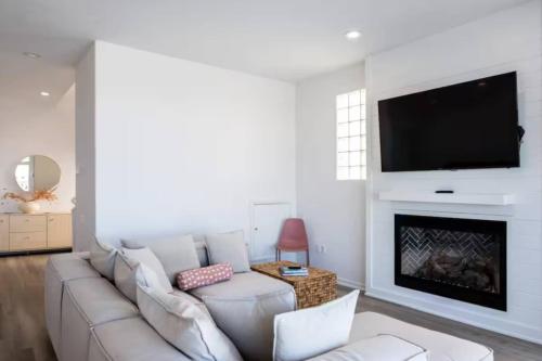 a living room with a white couch and a fireplace at Miami Vice Ocean City- 5BR | Private Pool | Views in Ocean City