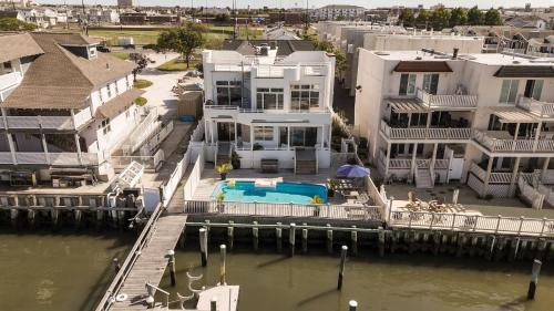 a large white house with a swimming pool in the water at Miami Vice Ocean City- 5BR | Private Pool | Views in Ocean City