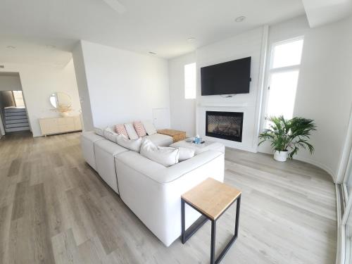 a white living room with a white couch and a fireplace at Miami Vice Ocean City- 5BR | Private Pool | Views in Ocean City