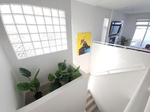 a white staircase with plants and a window at Miami Vice Ocean City- 5BR | Private Pool | Views in Ocean City