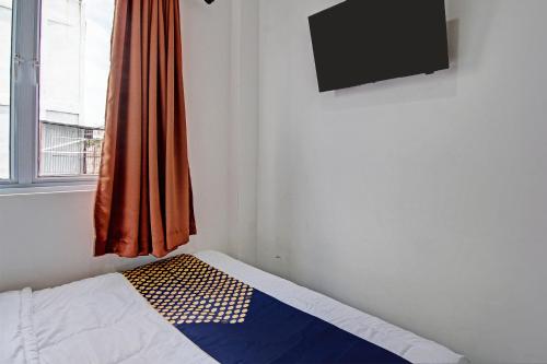 Una televisión o centro de entretenimiento en Hotel O Anugrah Jaya Syariah Near Sekolah Dasar Negeri 018 Desa Kubang Jaya