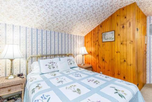 a bedroom with a bed and a wooden wall at Briarstone Inn Unit 5 in Galena