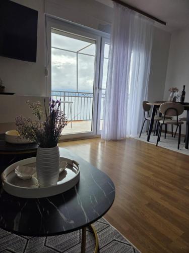 a living room with a table and a large window at VILA MARIJA in Mimice