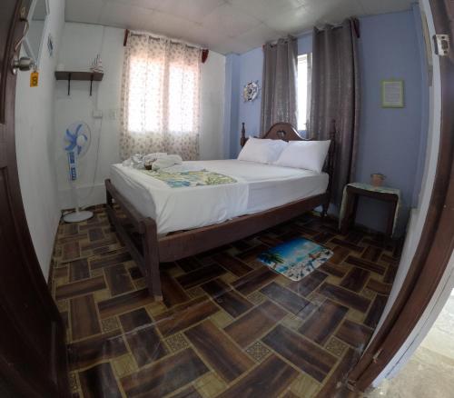 a bedroom with a bed and a wooden floor at Hospedaje Yosi & Pixvae Tours in Pixvae