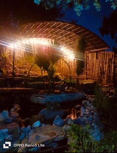a lit up building with a pond at night at Cabaña en la Calera Ciprés in La Calera