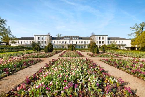 a garden with flowers in front of a building at Best Western Premier Park Hotel & Spa in Bad Lippspringe