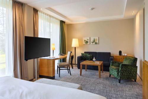 a hotel room with a bed and a living room at Best Western Premier Park Hotel & Spa in Bad Lippspringe