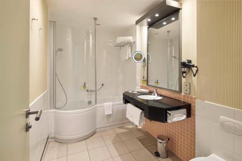 a bathroom with a shower and a sink and a toilet at Best Western Premier Park Hotel & Spa in Bad Lippspringe