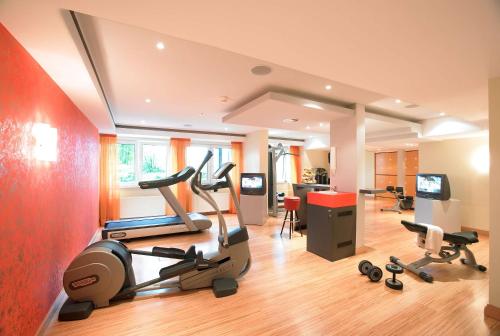a gym with cardio equipment in a room at Best Western Premier Park Hotel & Spa in Bad Lippspringe