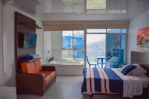 a bedroom with a bed and a chair and a window at HCR Hotel y Centro de Convenciones Chinauta Real in Fusagasuga