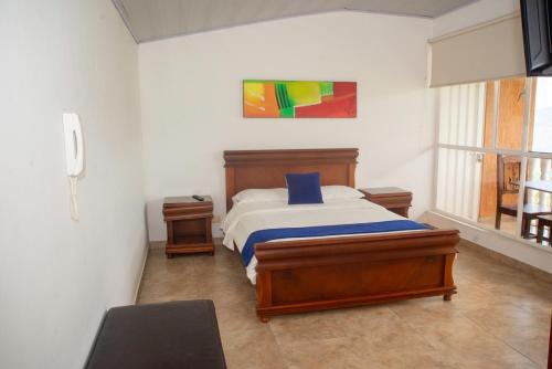 a bedroom with a bed with a blue pillow on it at HCR Hotel y Centro de Convenciones Chinauta Real in Fusagasuga