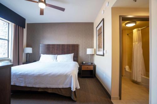 a hotel room with a bed and a walk in shower at Homewood Suites by Hilton, Durango in Durango