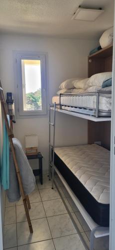 une chambre avec deux lits superposés et une fenêtre dans l'établissement Appartement front de mer et terrasse, à Vias