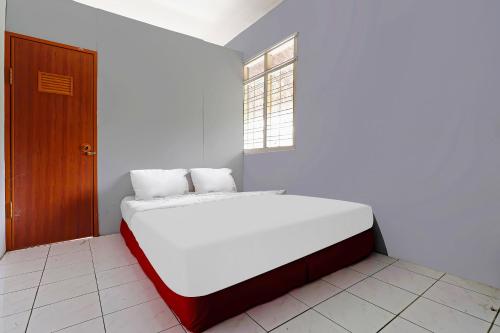 a white bed in a room with a window at OYO Life 92694 Kost Nino in Bandung