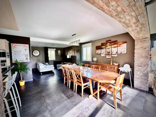 une salle à manger et un salon avec une table et des chaises dans l'établissement Les Palmiers gite 7 personnes plages du débarquement, à Grandcamp-Maisy