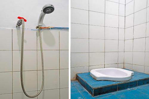 a bathroom with a shower and a toilet in it at OYO Life 92694 Kost Nino in Bandung