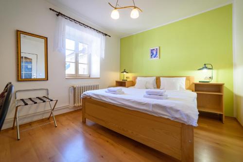 a bedroom with a large bed and a mirror at Penzion Markus - Pivovar - Brewery Frymburk in Frymburk