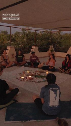a group of people sitting on the floor with candles at Pineapple Mansion in Paso Hondo