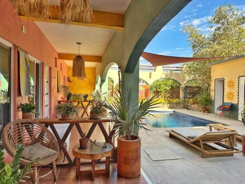 a patio with a table and chairs and a pool at Pineapple Mansion in Paso Hondo