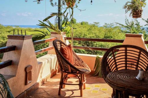 a patio with two chairs and a table on a balcony at Pineapple Mansion in Paso Hondo