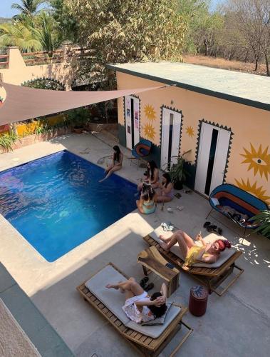 a group of people laying around a swimming pool at Pineapple Mansion in Paso Hondo