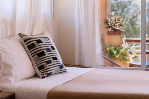 a bedroom with a bed with a pillow and a window at Pineapple Mansion in Paso Hondo