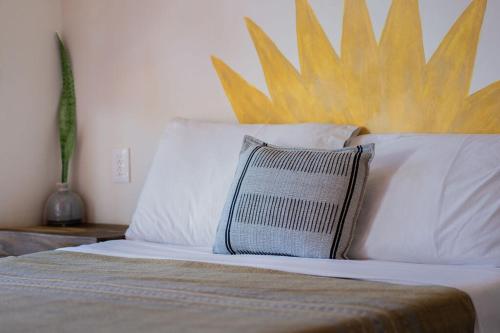 a bedroom with a bed with a giant sun on the wall at Pineapple Mansion in Paso Hondo