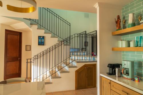 a kitchen with a spiral staircase in a house at Bougainvillea 7315 Luxury Penthouse- Reserva Conchal in Playa Conchal