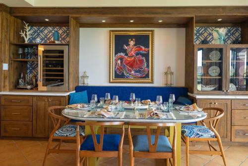 a dining room with a table with blue chairs at Bougainvillea 7315 Luxury Penthouse- Reserva Conchal in Playa Conchal