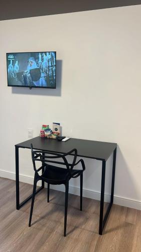 a black desk with a chair in front of a wall at Samba Betim in Betim