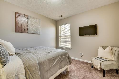 a bedroom with a bed and a tv and a chair at 10 Mi to Six Flags Austell Home with Expansive Yard in Austell