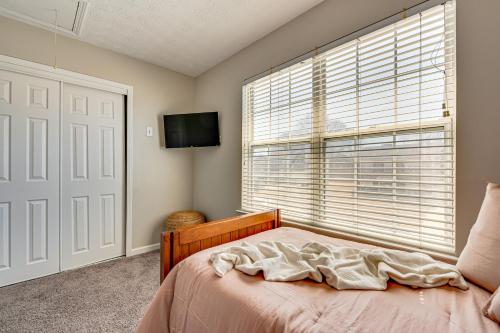 a bedroom with a bed and a window with a television at 10 Mi to Six Flags Austell Home with Expansive Yard in Austell