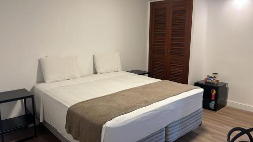 a bedroom with a large bed with a brown door at Samba Betim in Betim