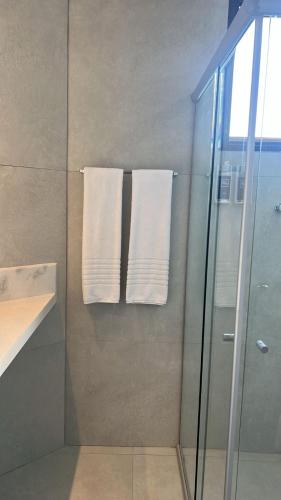 a bathroom with a shower and two white towels at Samba Betim in Betim