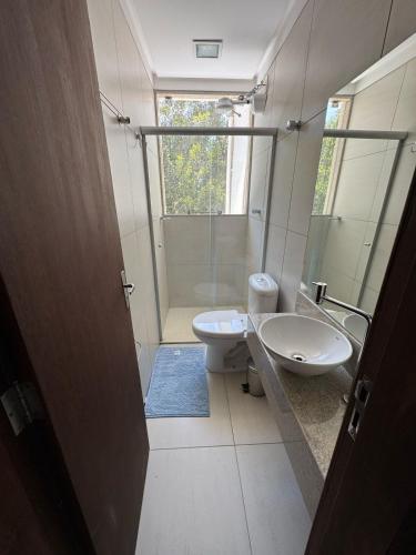 a bathroom with a toilet and a sink and a shower at Apartmento - Lago das Roseiras in Divinópolis