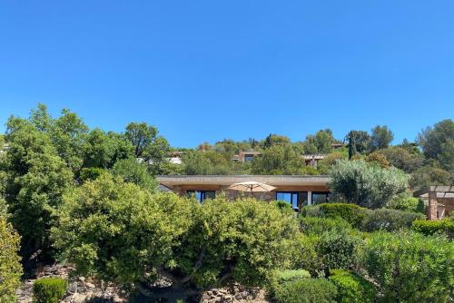 a house on top of a hill with trees at Superbe petite villa moderne surplombant la mer in Saint-Raphaël