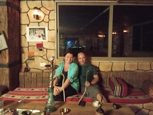 a man and a woman sitting on a couch at Dana Valley Tourism Hotel in Dana