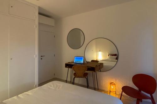 a bedroom with a bed and a desk with a laptop at Superbe petite villa moderne surplombant la mer in Saint-Raphaël