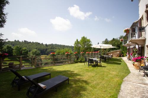 a garden with tables and chairs and an umbrella at Ongar Relax b&b in Bosco Chiesanuova