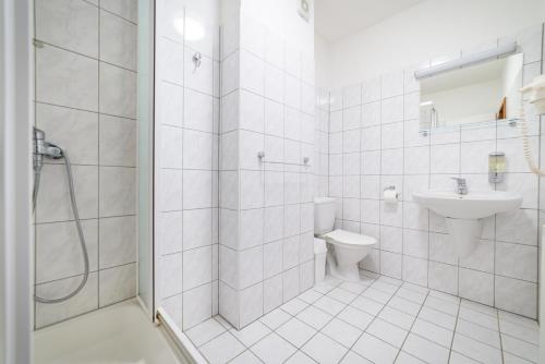 a white bathroom with a toilet and a sink at Penzion Markus - Pivovar - Brewery Frymburk in Frymburk