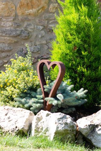 a metal heart in the middle of a garden at Ongar Relax b&b in Bosco Chiesanuova