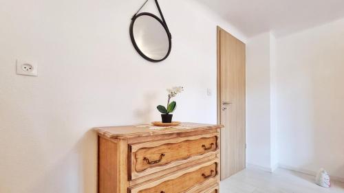 a mirror sitting on top of a wooden dresser in a room at Gite A la Fontaine Bergheim in Bergheim