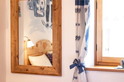 a mirror on a wall next to a window at Ongar Relax b&b in Bosco Chiesanuova