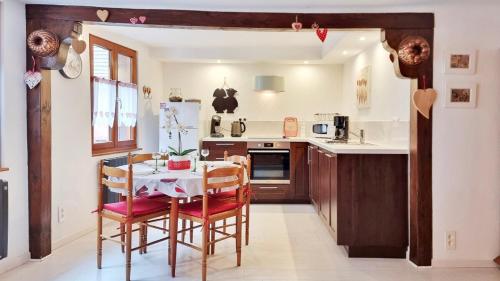 a kitchen with a table and chairs in a room at Gite A la Fontaine Bergheim in Bergheim